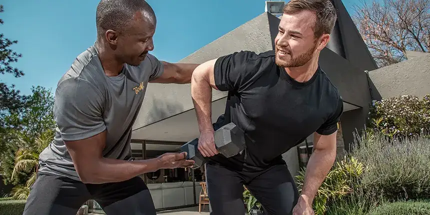 Personal trainer coaching compound movements at home
