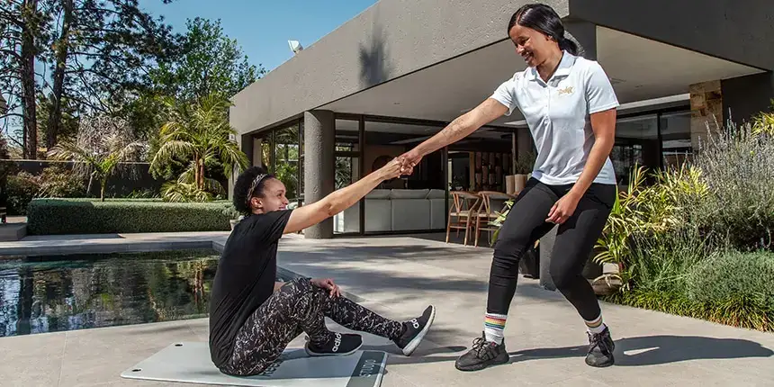 Personal trainer motivating a client during an at-home training session